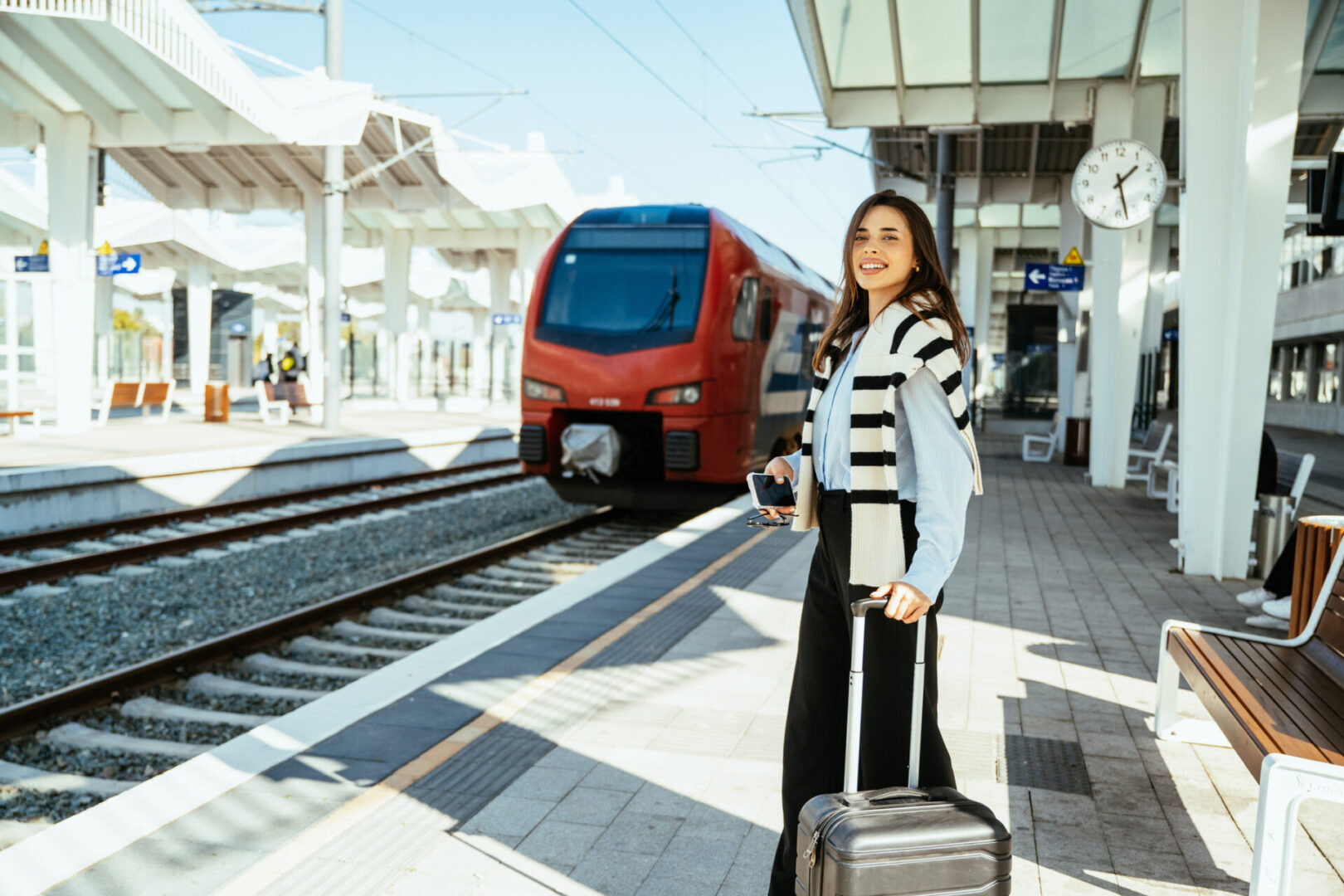 Woman with suitcase on train platform.