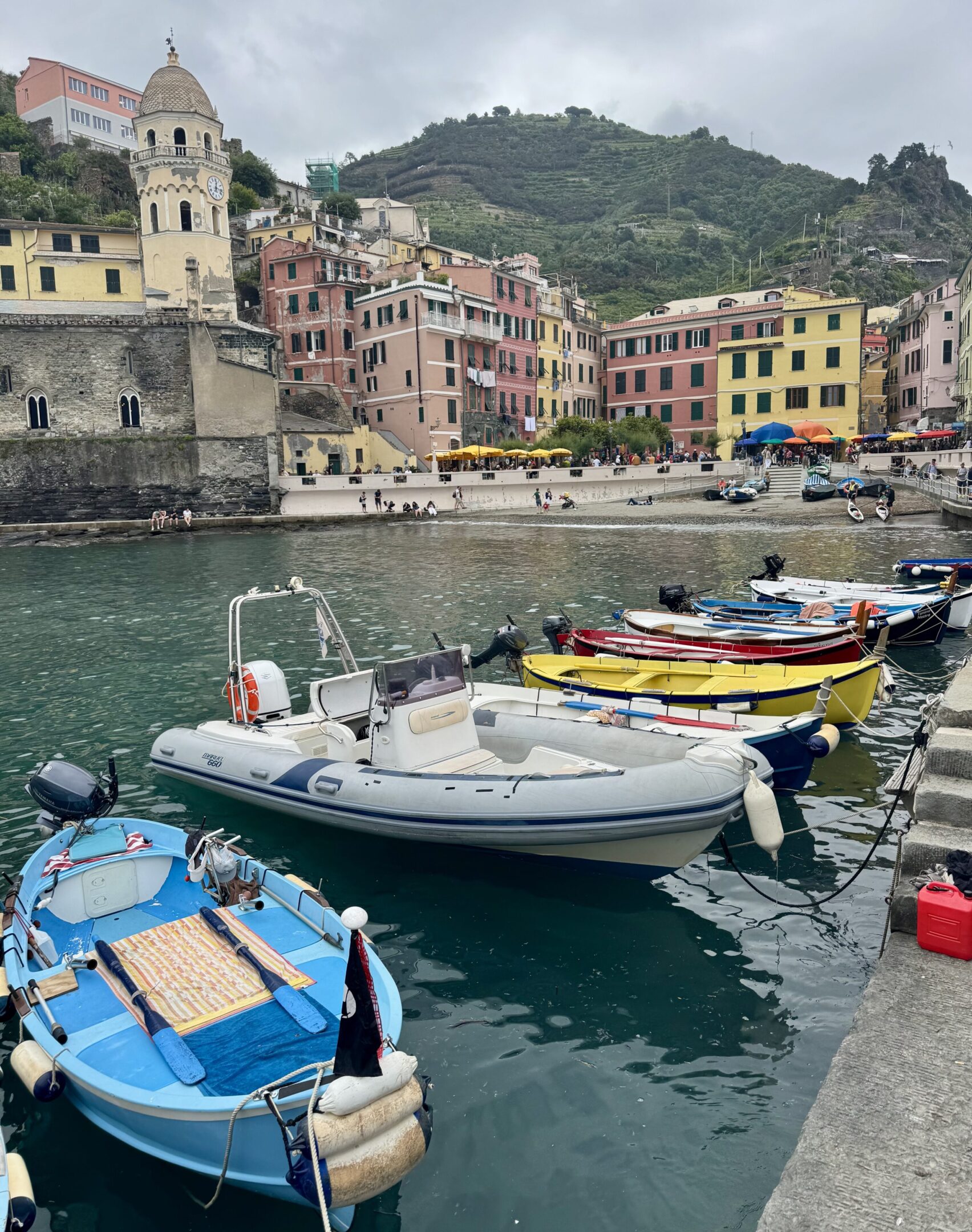 Colorful boats docked in a scenic coastal village harbor.