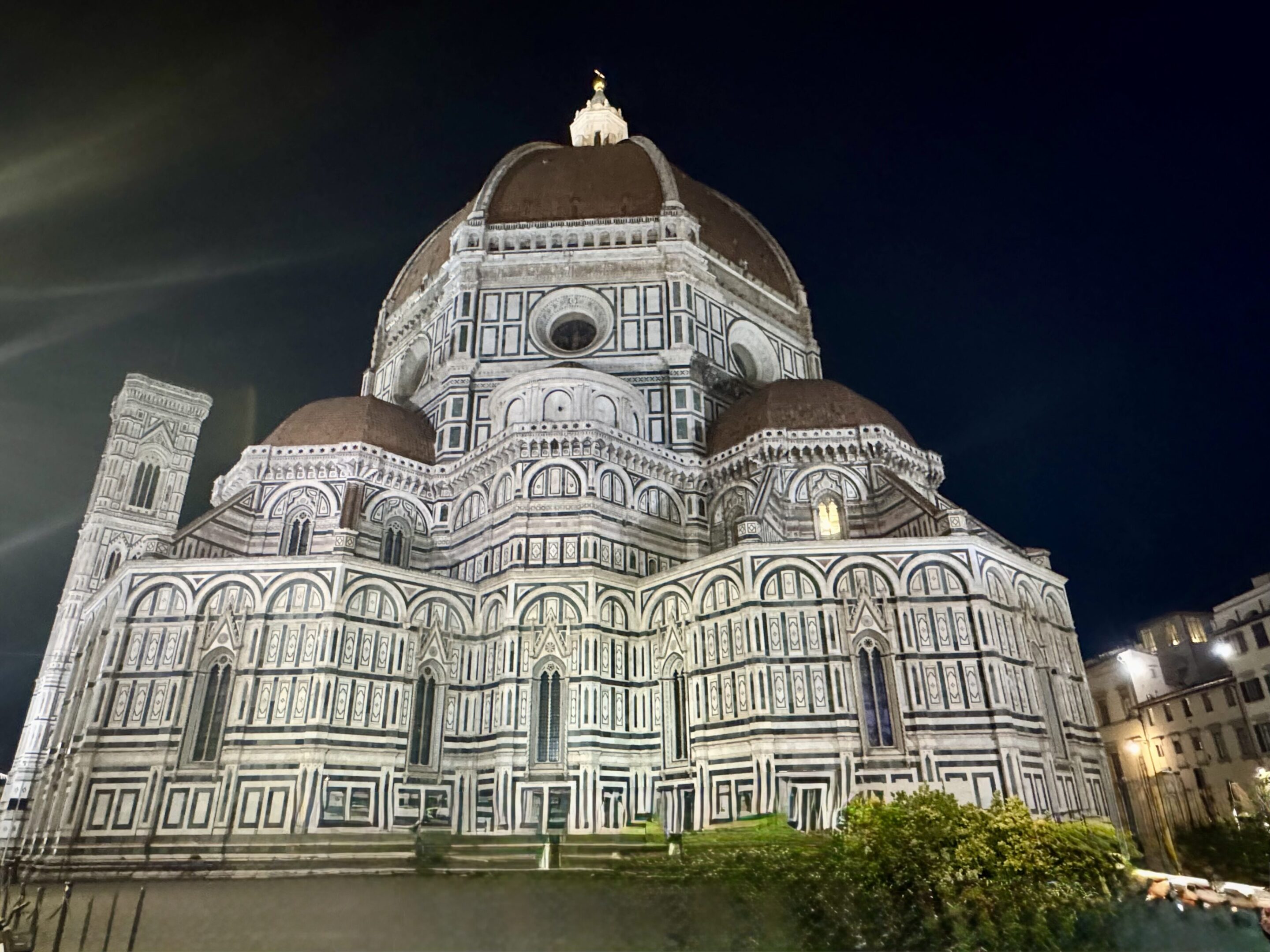 Illuminated ornate cathedral facade at night with intricate geometric patterns.