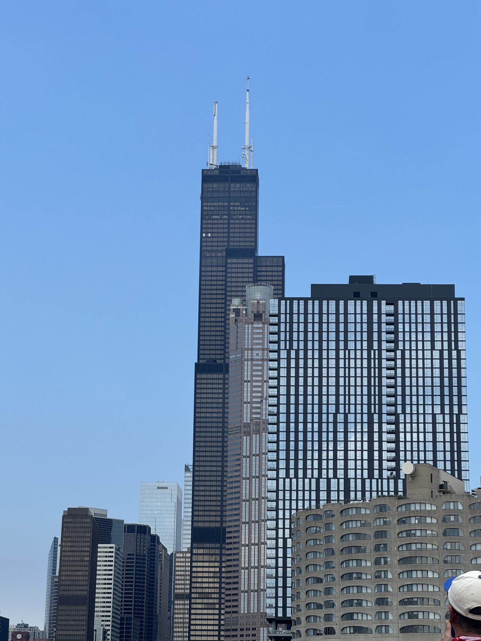 Tall skyscraper with antennas under a clear blue sky.